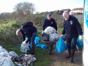 Regular Cray Riverkeeper volunteers Ray, Malcolm, Ron and Trevor shift the accumulated rubbish to the end of the footpath ready for collection by Bexley Council. Material in the clear bags  most of it discarded beer cans - has been separated for recycling. (Photo: Pamela Zollicoffer)